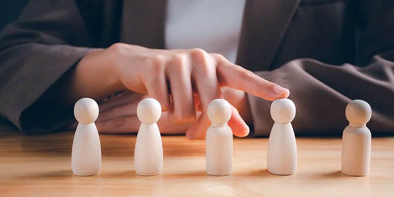 IT Staff Nearshoring with a man choosing the right staff using a wooden peg